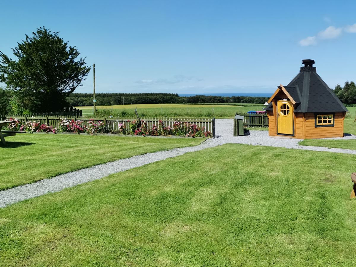 The barbecue hut and pods with the sea on the horizon
