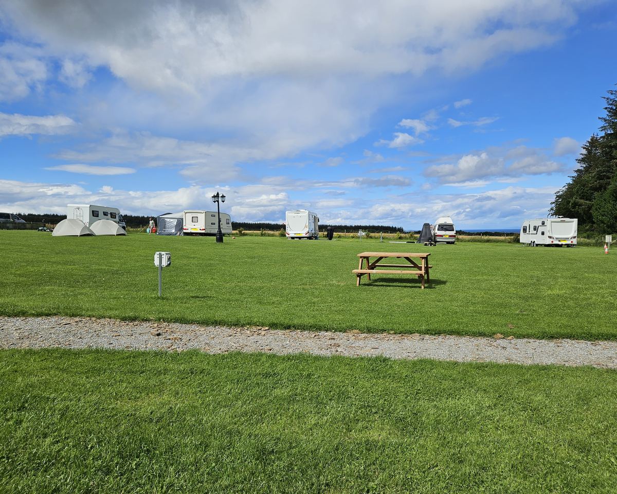 Caravans and tents on the pitches at Greencraig under a big summer sky